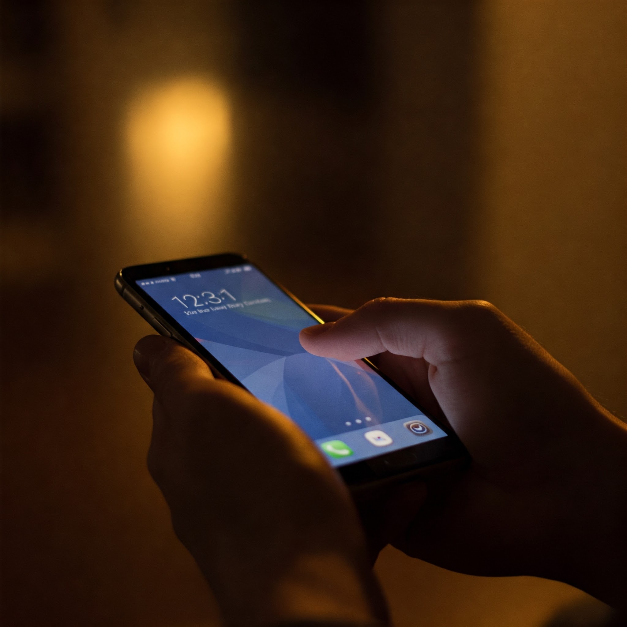 photo of Person Using Smartphone in Low Light
